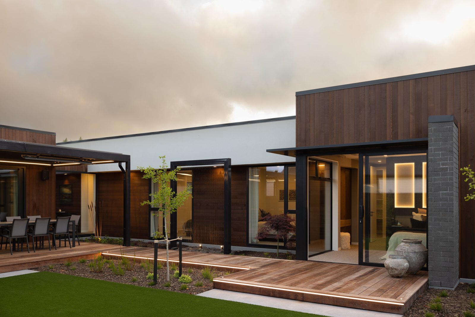 Wide view of the steel pergola and deck with slim edge columns, Hallmark Homes Oakbridge showhome at dusk