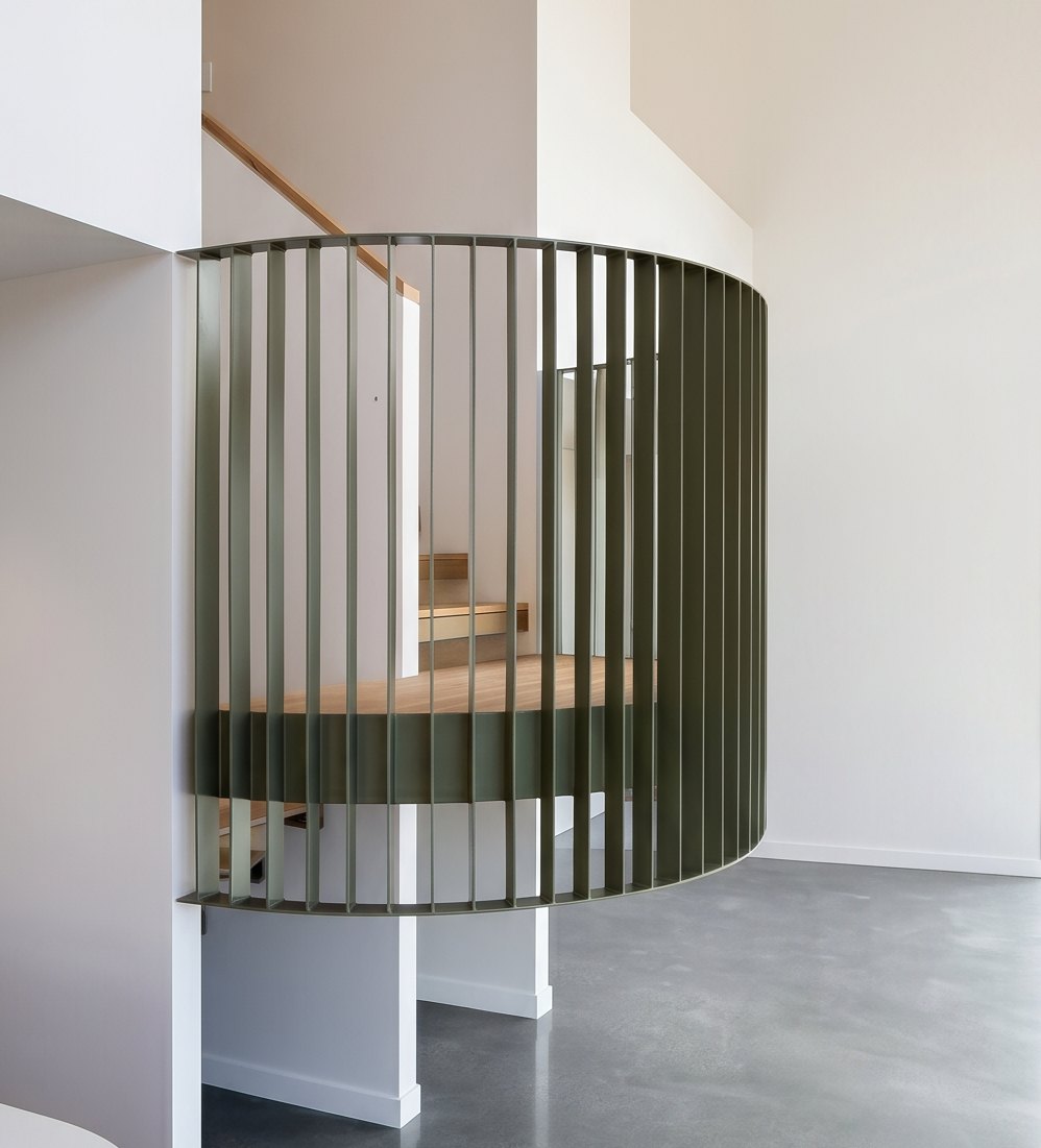 Floating circular staircase inside a surround of thin olive-green flat-bar steel, a recent ARC project in Mt Pleasant, Christchurch