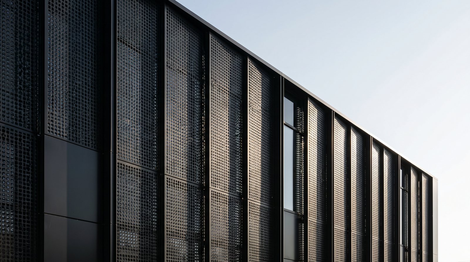 Perforated steel facade panels on a commercial building, by ARC Design Studio
