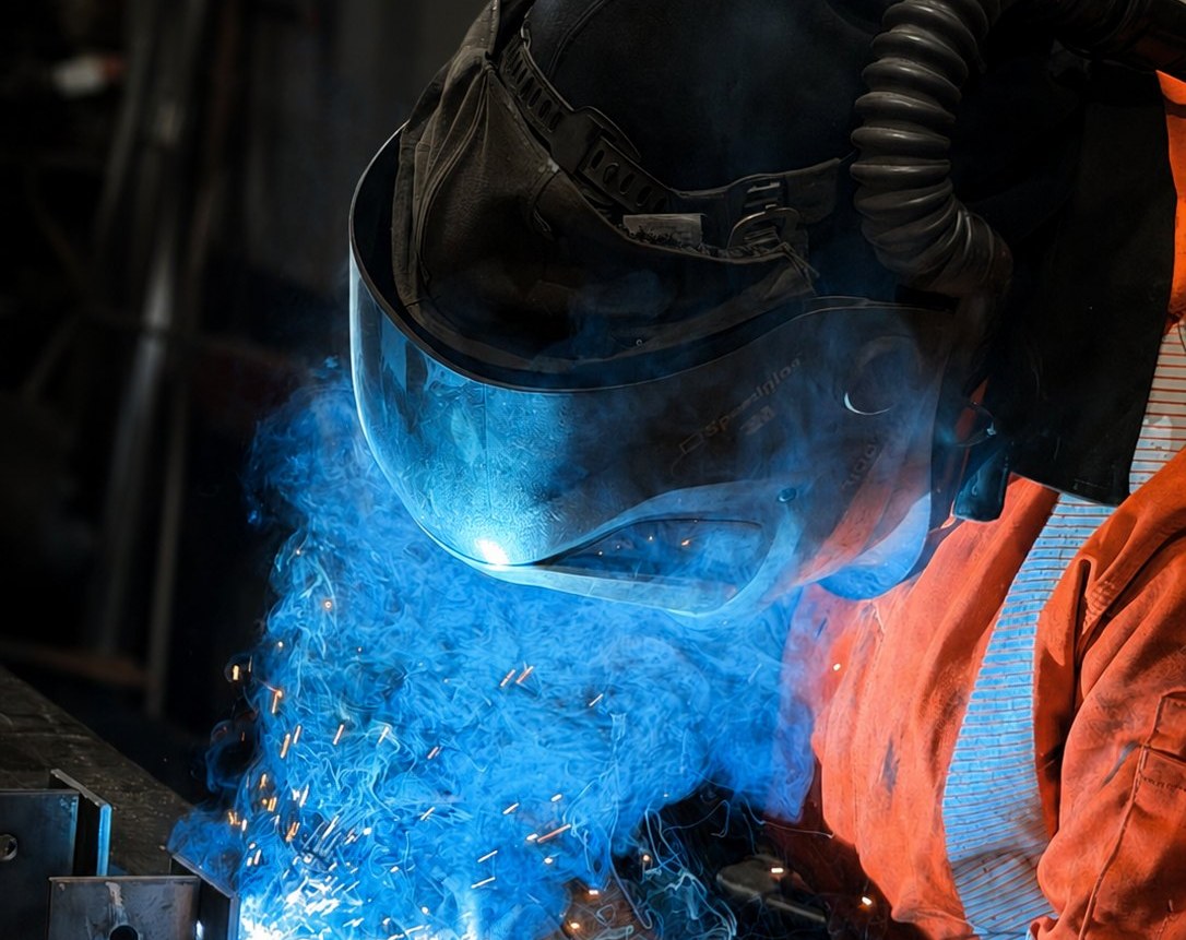 A Bromley Steel welder fabricating architectural steel, sparks and blue arc light